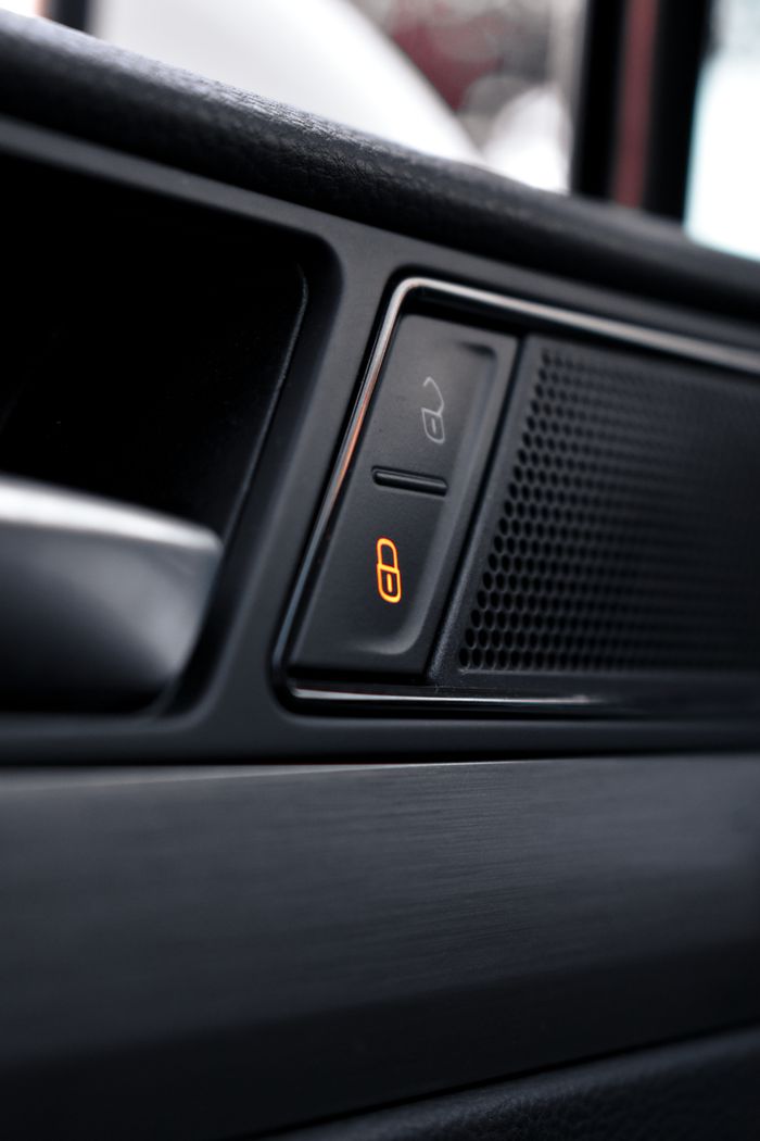 Close-up view of a car's interior door lock and speaker, showcasing modern design and functionality.